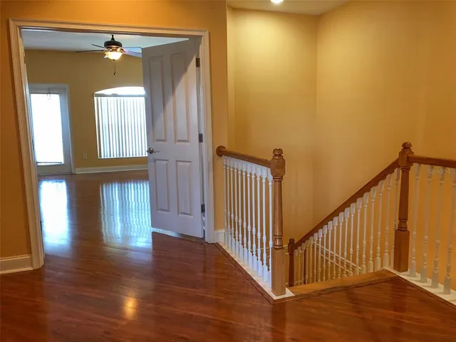 a view of a hallway with wooden floor and stairs
