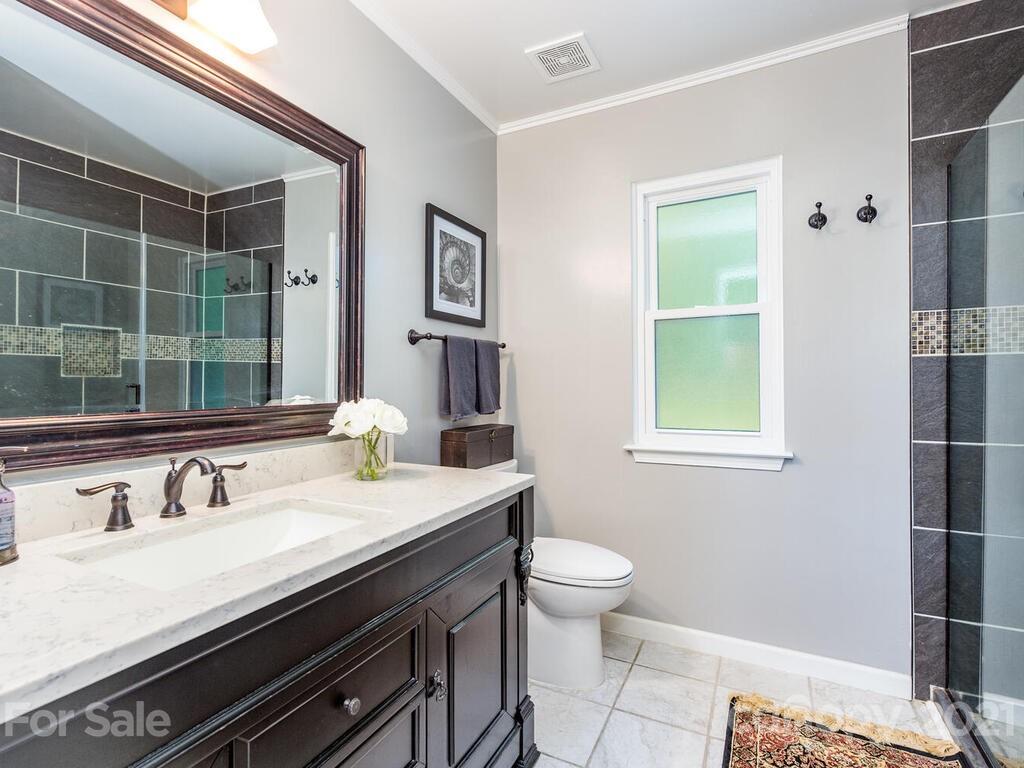 595 Hunters Ridge Road, Unit 20 Canton, NC 28716 - Photo 17 of 47 a bathroom with a granite countertop sink a toilet and a mirror
