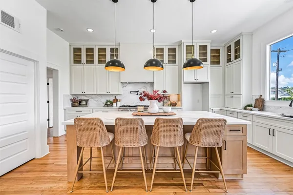 a kitchen with stainless steel appliances granite countertop a sink a stove and a wooden floors