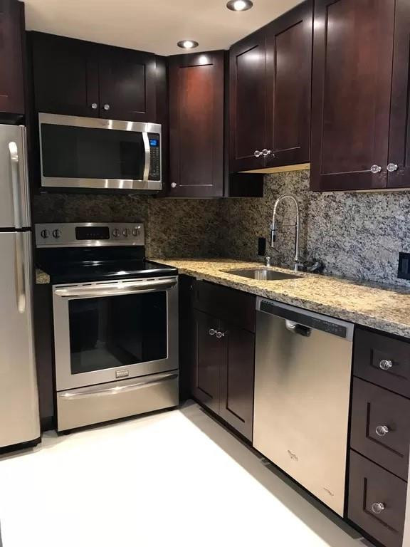 21 Dorset A Boca Raton, FL 33434 - Photo 1 of 7 a kitchen with stainless steel appliances granite countertop a stove and a microwave