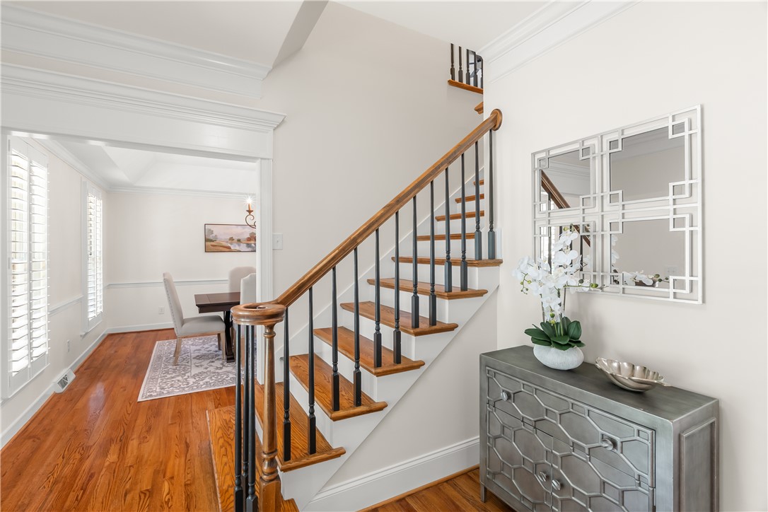 This inviting entryway features rich wood flooring, leading to a dining area.