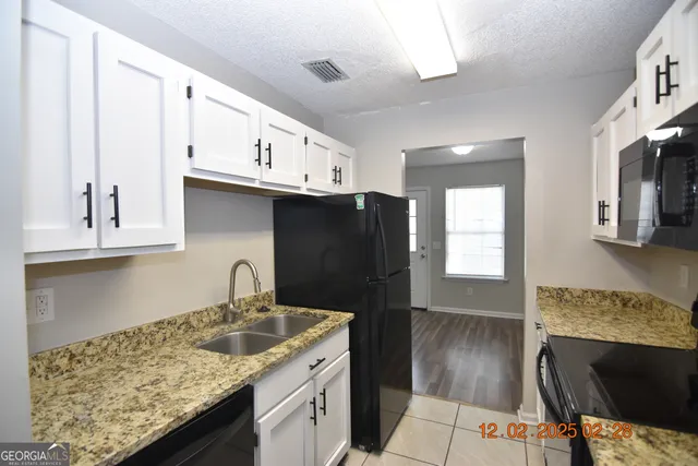a kitchen with granite countertop a sink and cabinets