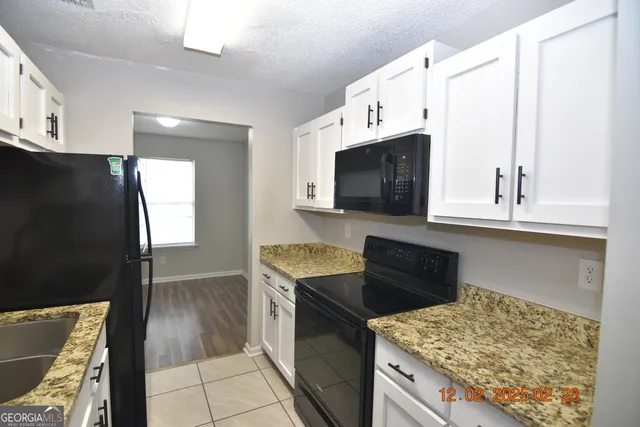 a kitchen with stainless steel appliances granite countertop a stove a microwave and a refrigerator