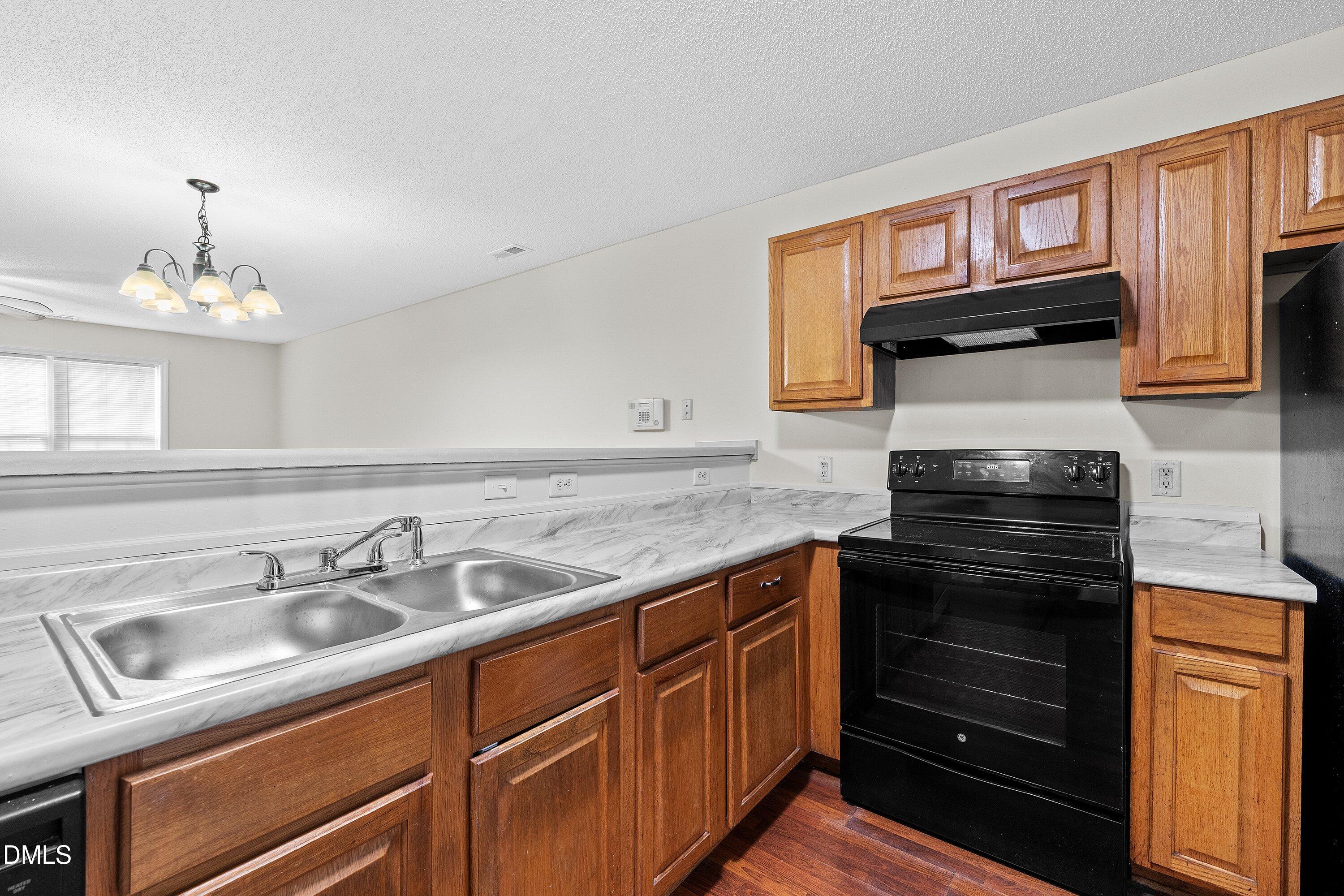 2241 Violet Bluff Court Raleigh, NC 27610 - Photo 11 of 28 a kitchen with granite countertop a sink stove and cabinets