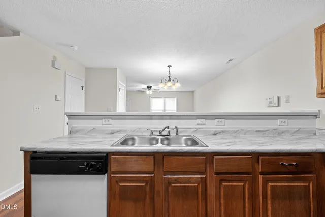 a kitchen with granite countertop a sink stove and cabinets