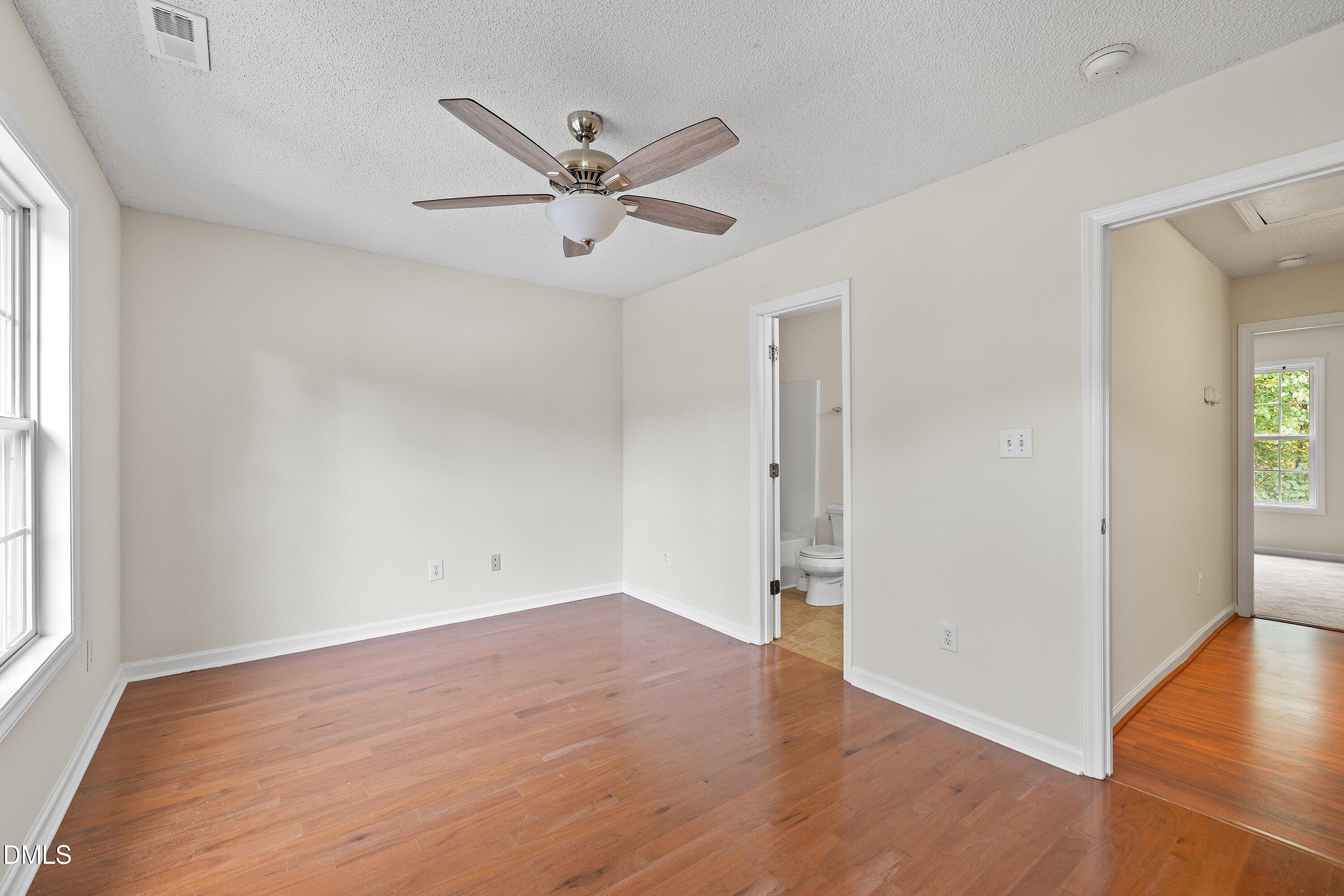 2241 Violet Bluff Court Raleigh, NC 27610 - Photo 15 of 28 an empty room with wooden floor fan and windows