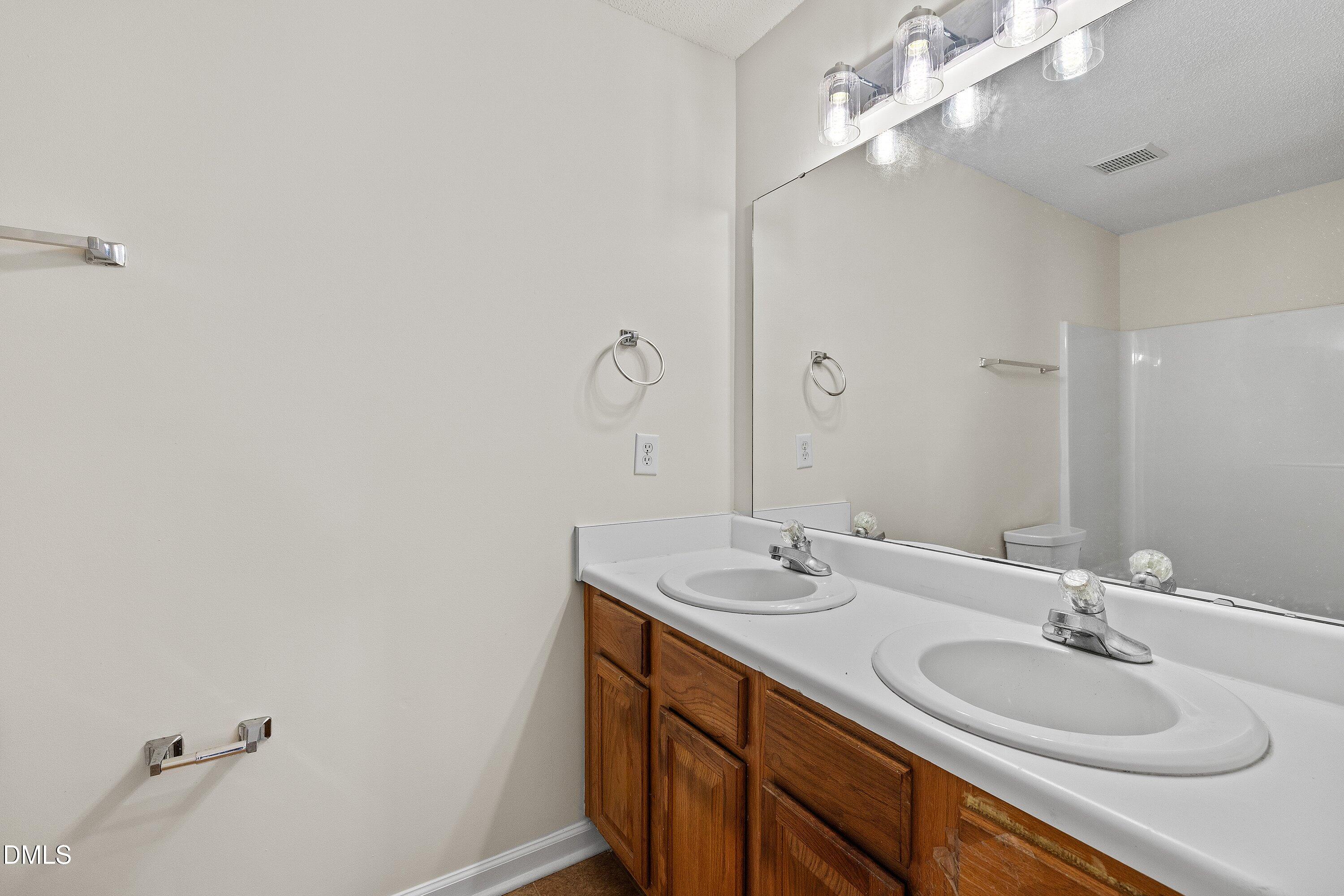 2241 Violet Bluff Court Raleigh, NC 27610 - Photo 17 of 28 a bathroom with a double vanity sink and a mirror