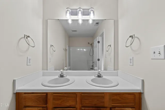 a bathroom with a double vanity sink and a mirror