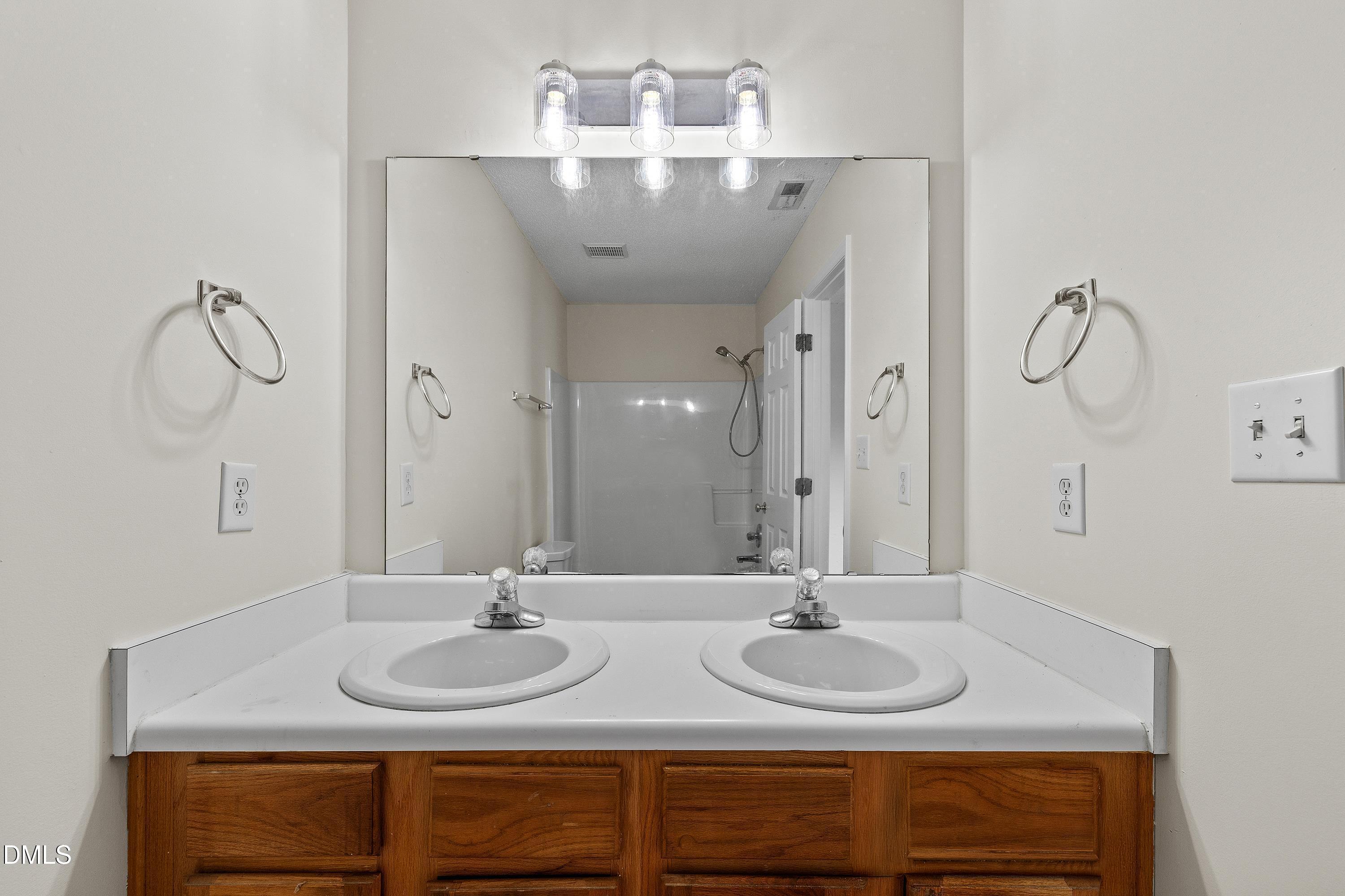 2241 Violet Bluff Court Raleigh, NC 27610 - Photo 18 of 28 a bathroom with double vanity sinks and a mirror