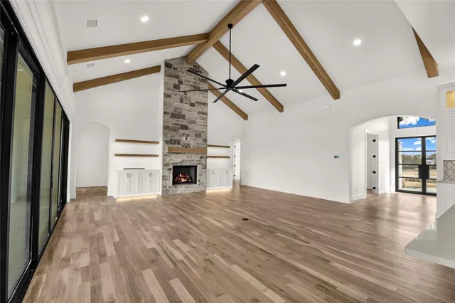 a view of empty room with wooden floor and fireplace