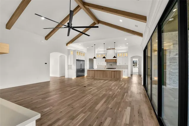 a view of empty room with wooden floor and windows