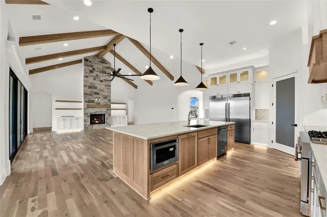 a open kitchen with stainless steel appliances granite countertop a sink a stove and a refrigerator