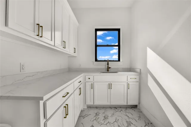 a kitchen with white cabinets appliances and sink