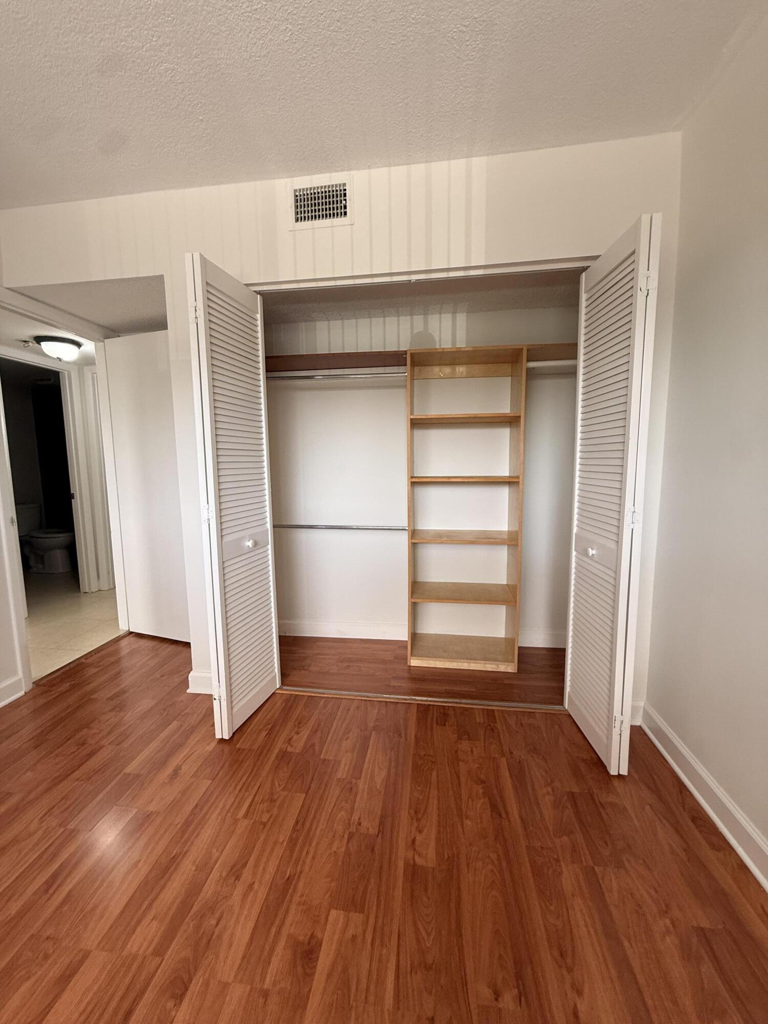 875 Northwest 13th Street, Unit 405 Boca Raton, FL 33486 - Photo 11 of 16 a view of empty room with wooden floor and window
