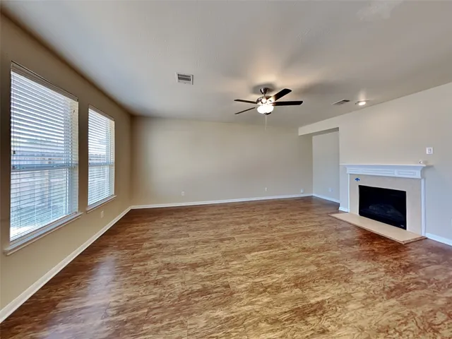 a view of an empty room with a fireplace and a window