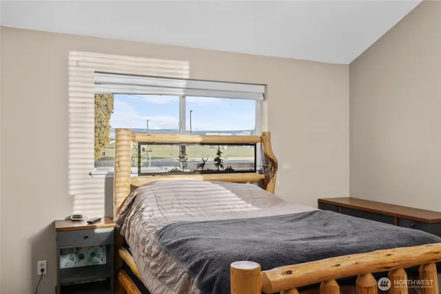 a bed sitting in a bedroom next to a window