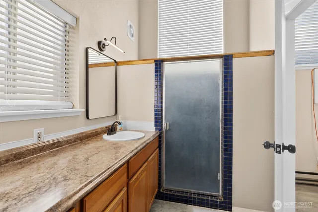 a bathroom with a granite countertop sink and a mirror