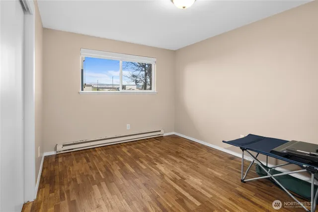 a view of an empty room with wooden floor