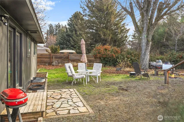 a view of a chairs and table in the back yard of the house