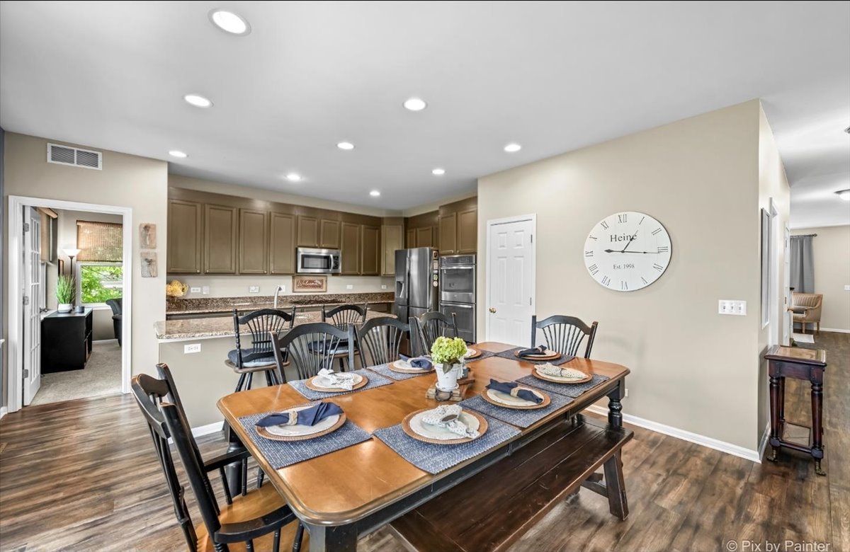 237 Foxford Drive Cary, IL 60013 - Photo 18 of 66 a view of a dining room and livingroom with furniture wooden floor a chandelier