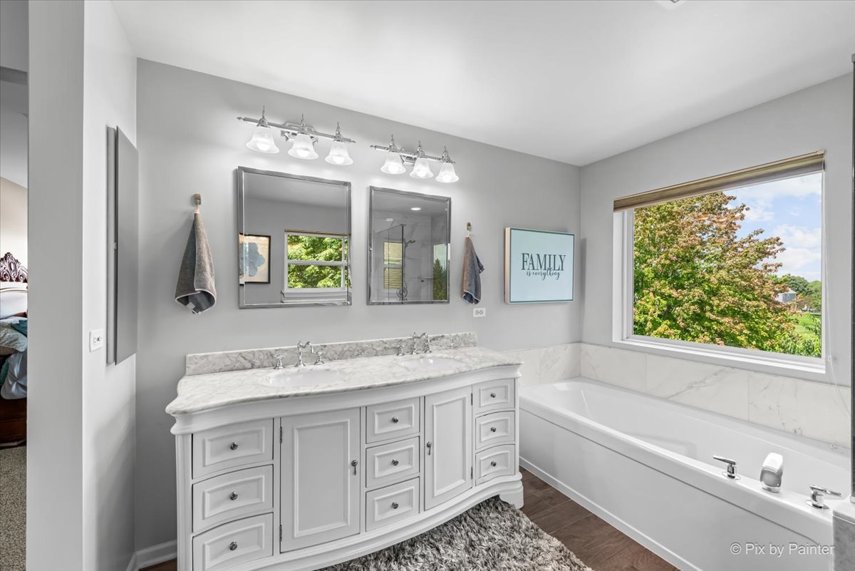 237 Foxford Drive Cary, IL 60013 - Photo 33 of 66 a bathroom with a granite countertop tub a double vanity sink a vanity a window and a mirror
