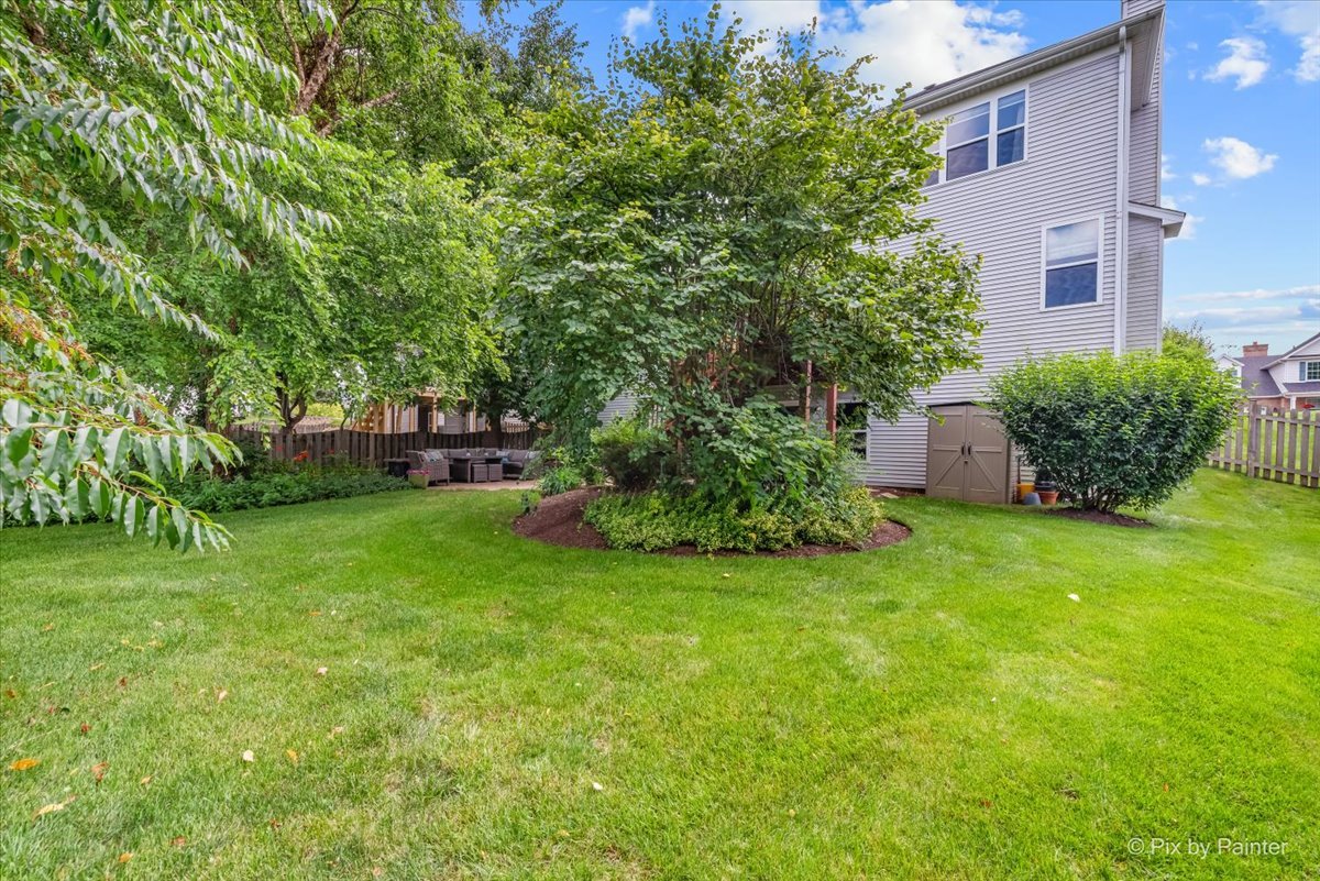 237 Foxford Drive Cary, IL 60013 - Photo 63 of 66 a view of a backyard with potted plants and large trees