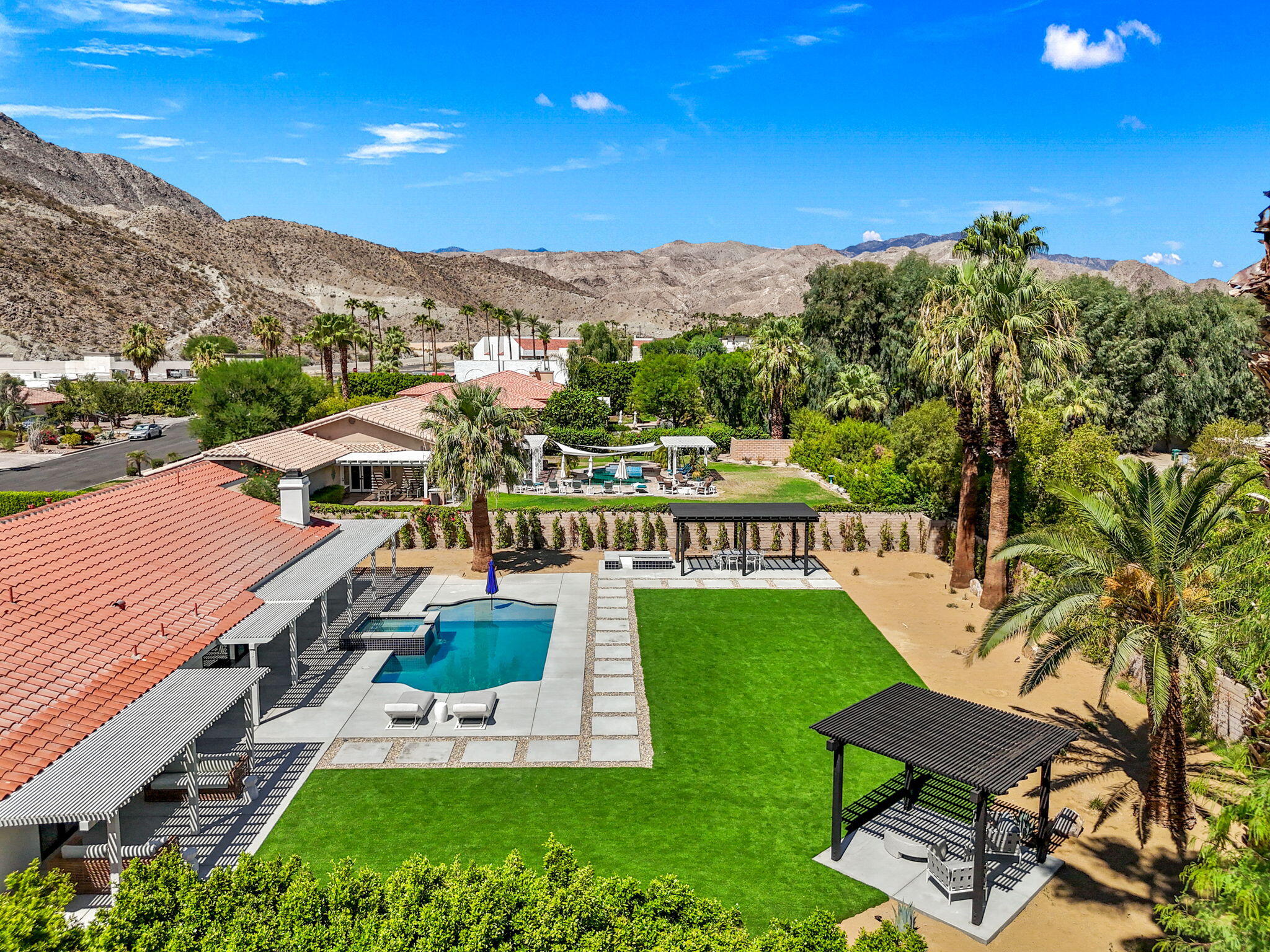 72278 Barbara Drive Rancho Mirage, CA 92270 - Photo 4 of 69 a view of a swimming pool with lawn chairs under an umbrella