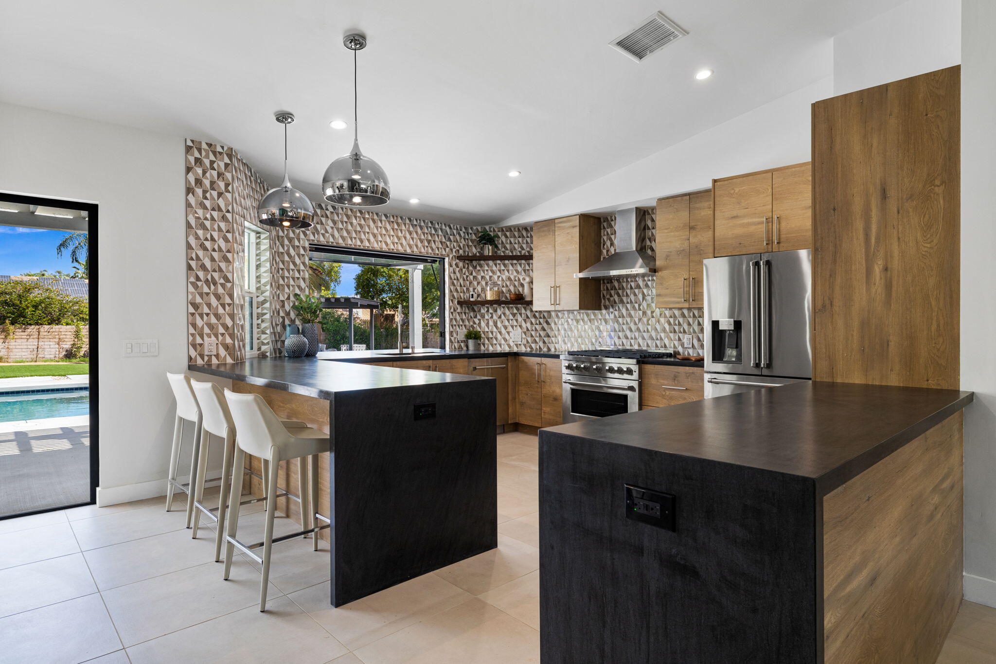 72278 Barbara Drive Rancho Mirage, CA 92270 - Photo 55 of 69 a kitchen with stainless steel appliances granite countertop a refrigerator a sink dishwasher a stove and a dining table with wooden floor