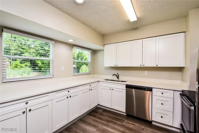 a kitchen with white cabinets stainless steel appliances and refrigerator