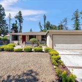 front view of a house with a yard and potted plants