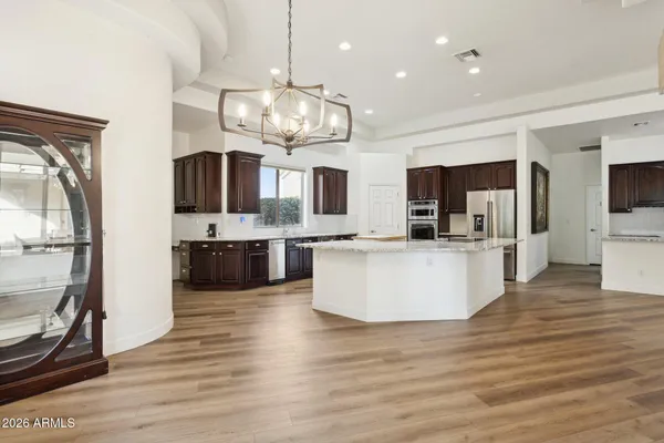 a large living room with stainless steel appliances kitchen island granite countertop a large kitchen island and a couch