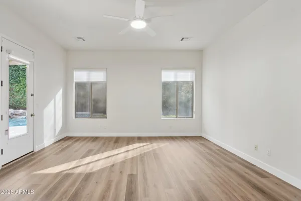 an empty room with wooden floor and windows