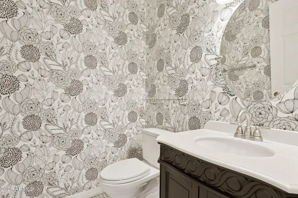 a bathroom with a granite countertop toilet sink and mirror