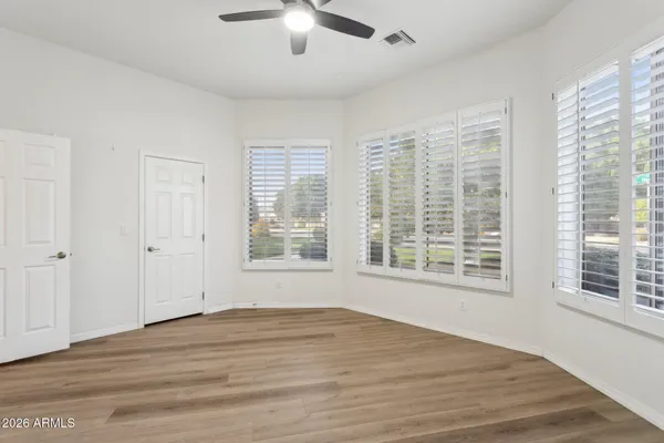 a view of an empty room with a window and wooden floor