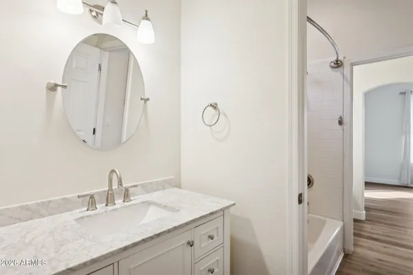 a bathroom with a granite countertop sink a mirror and shower