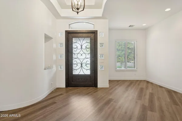 an empty room with wooden floor closet and windows