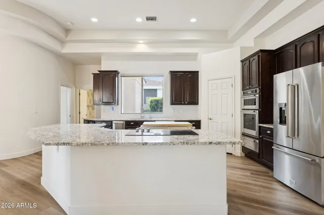 a kitchen with granite countertop a sink and a wooden floor
