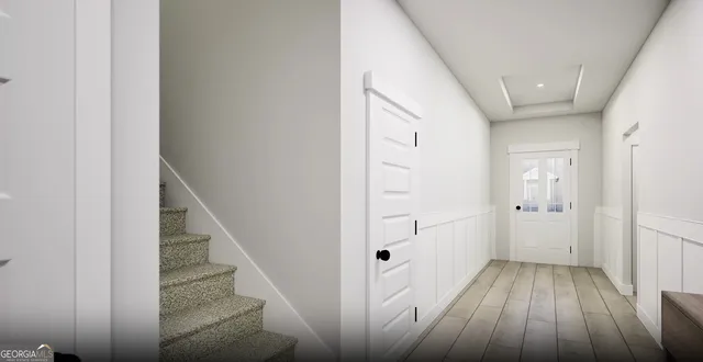 a view of a hallway with wooden floor and entryway