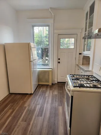 a kitchen with wooden floors and white appliances