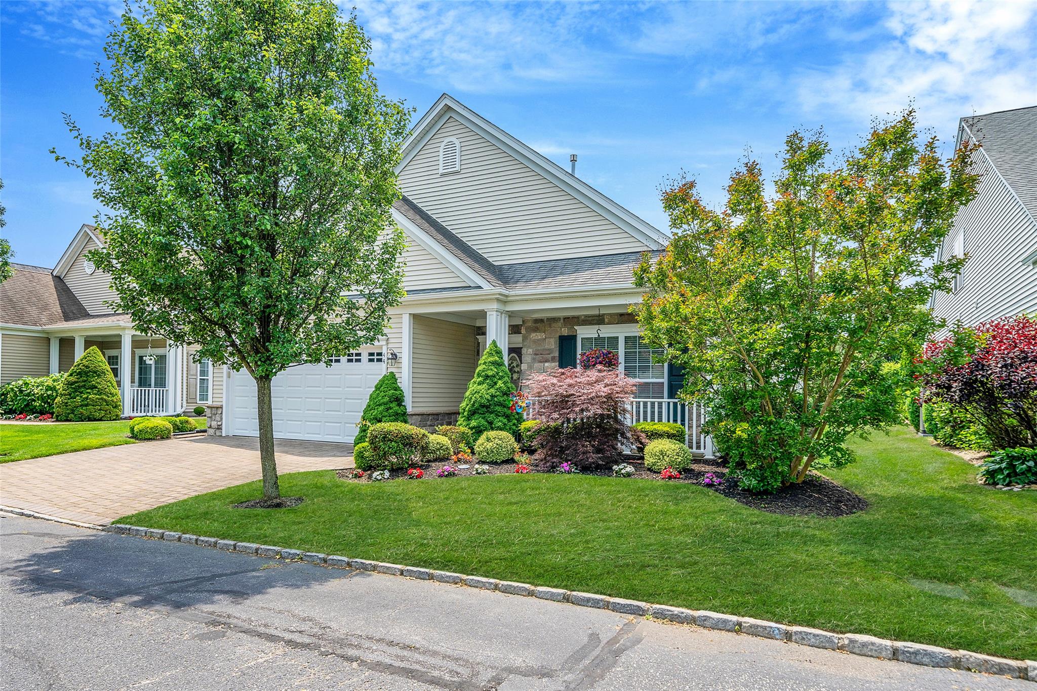 a front view of a house with a garden and plants