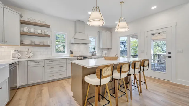 a kitchen with granite countertop white cabinets and a large window