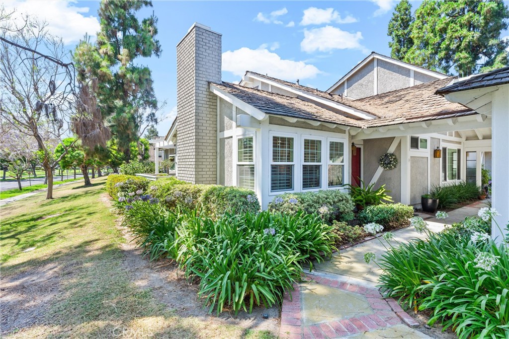 6 Goldstone, Unit 14 Irvine, CA 92614 - Photo 1 of 1 a view of a white house next to a yard with potted plants