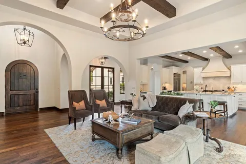 a living room with furniture a dining table and a chandelier