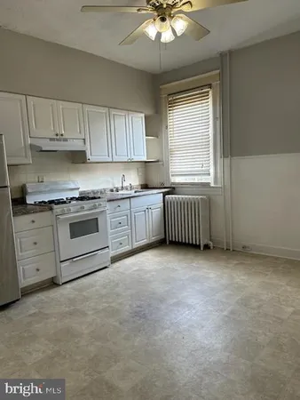 a kitchen with a stove a sink and cabinets