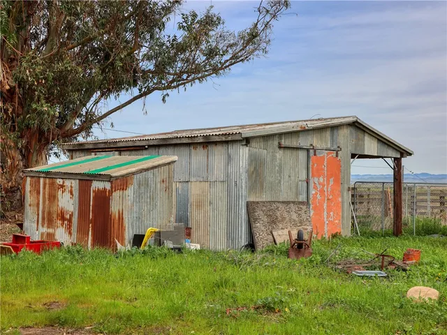a backyard of a house with barbeque oven table and chairs