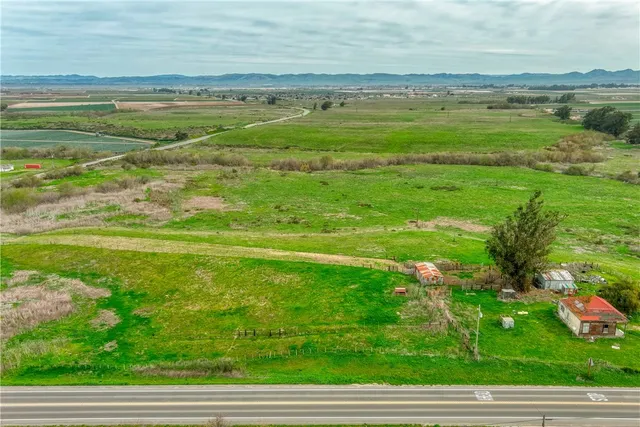 a view of a field of grass and houses