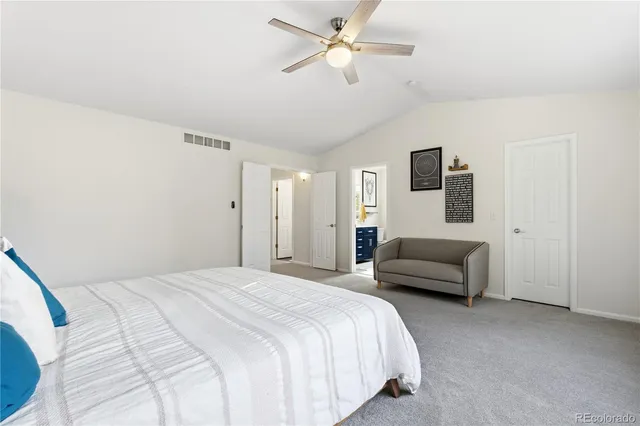 a bedroom with a bed ceiling fan and a wooden floor