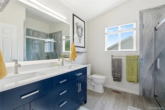 a bathroom with a double vanity sink toilet and a mirror