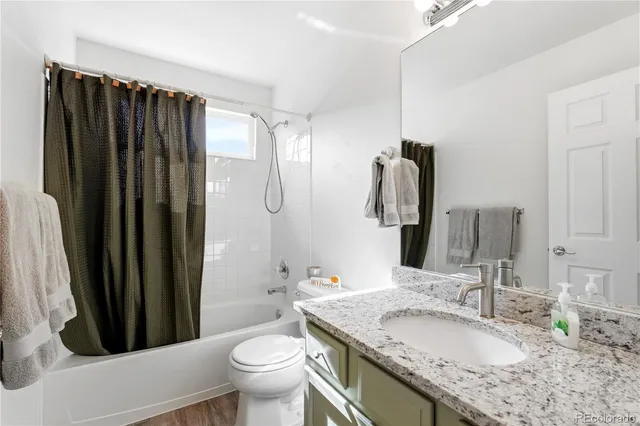a bathroom with a granite countertop sink toilet and shower