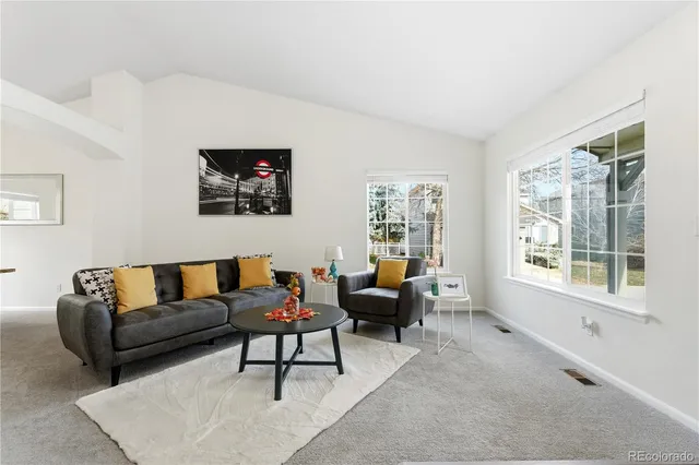 a living room with furniture a rug a lamp and a window